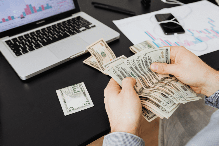 Person counting the money generated after following the marketing strategy and finding out why most artists fail to find a label deal. 
