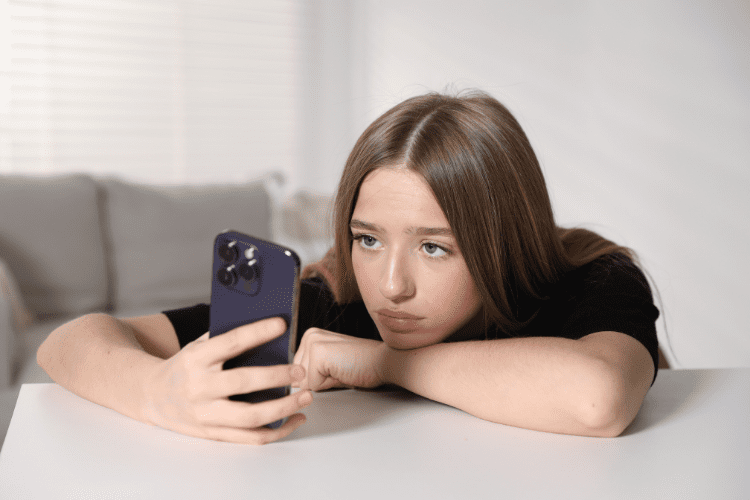 Sad independent artist looking at her phone wondering why her music doesn't make any streams. 