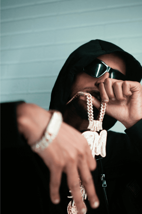 independent artist flexing his cuban links but is not doing so well financially because his ego is ruining his career. He is not focusing on business aspect of his career enough and just spends his money carelessly